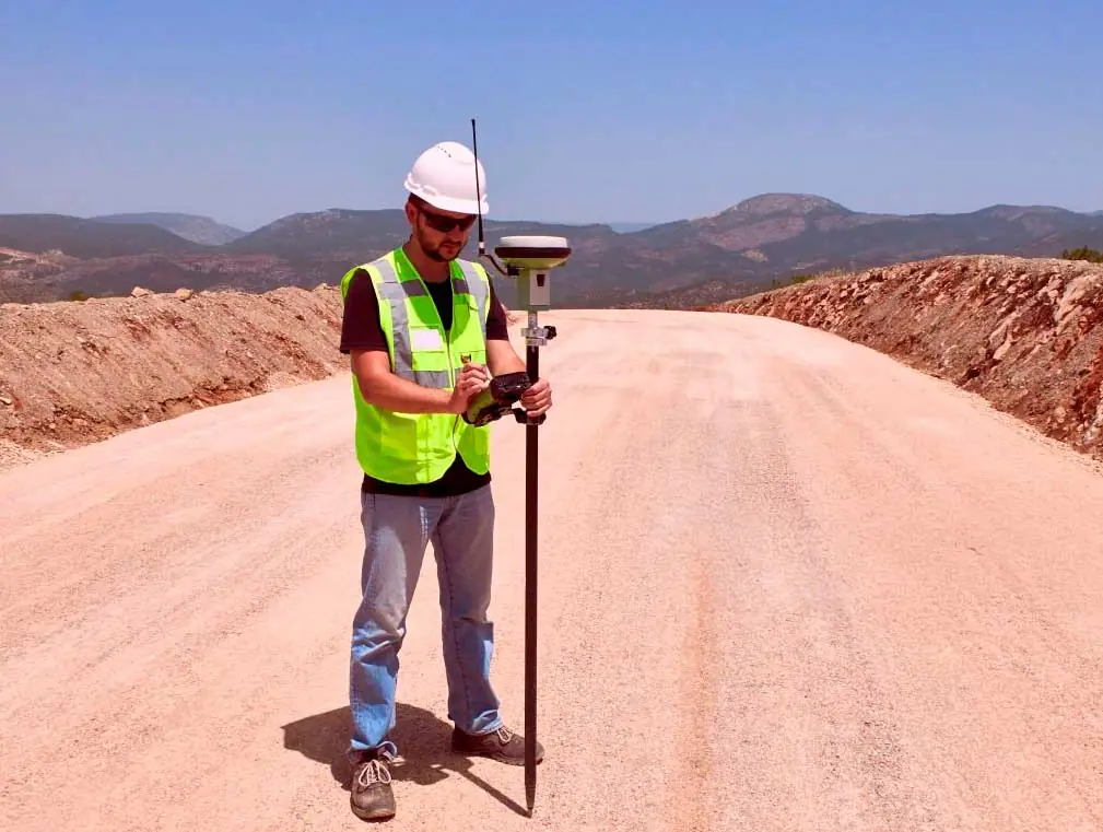 Topógrafo operando equipo GNSS RTK en terreno rural